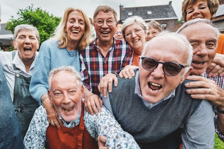 Group of smiling seniors standing outdoors in a circle before an AI workshop